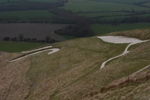 The white chalk lines of the Uffington White Horse on the hillside above the Vale