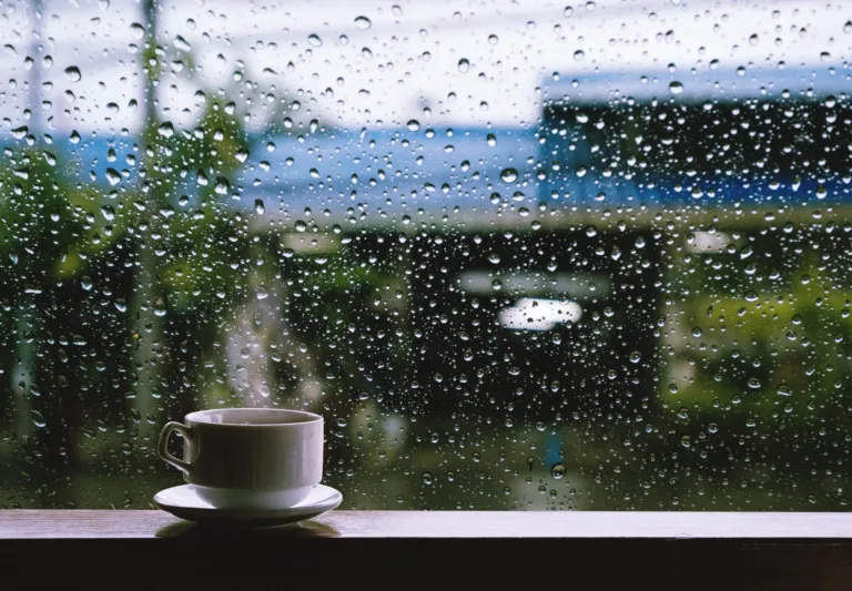 Rain on a window beside a cup of tea